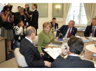 Bundeskanzlerin Angela Merkel spricht mit Russlands Präsident Wladimir Putin zu Beginn der zweiten Arbeitssitzung.
