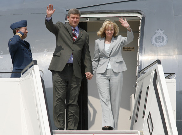 Canadian Prime Minister Stephen Harper and his wife, Laureen Harper, wave from the gangway of their aeroplane