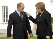 Bundeskanzlerin Angela Merkel zeigt auf den Anstecker am Revers des russischen Präsidenenten Wladimir Putin in Heiligendamm