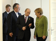 Der russische Präsident Wladimir Putin im Gespräch mit Bundeskanzlerin Angela Merkel vor Beginn der ersten Arbeitssitzung in Heiligendamm