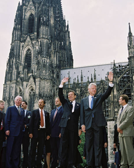 Bundeskanzler Gerhard Schröder und der amerikanische Präsident Bill Clinton winken der anwesenden Bevölkerung vor dem Kölner Dom zu.