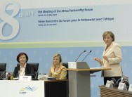 Wieczorek-Zeul on the stage, Merkel at the lectern