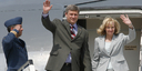 Canadian Prime Minister Stephen Harper and his wife, Laureen Harper, wave from the gangway of their aeroplane