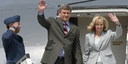 Canadian Prime Minister Stephen Harper and his wife, Laureen Harper, wave from the gangway of their aeroplane