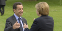 German Chancellor Angela Merkel welcomes French President Nicolas Sarkozy in the park in Heiligendamm