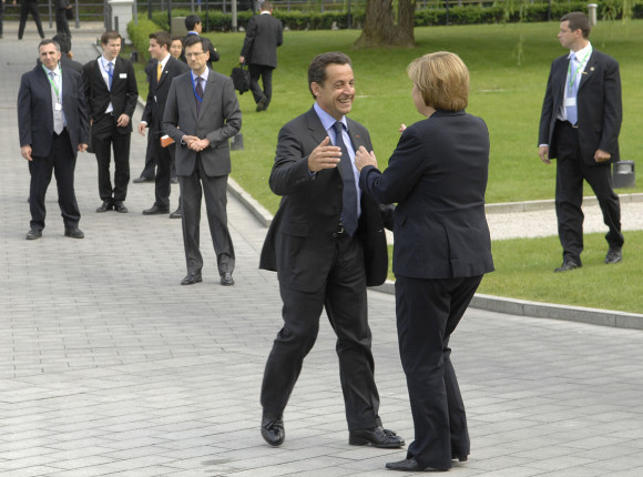 German Chancellor Angela Merkel welcomes French President Nicolas Sarkozy in the park in Heiligendamm