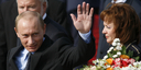 Russian President Vladimir Putin waves on arrival, accompanied by his wife Ludmila Alexandrovna Putina